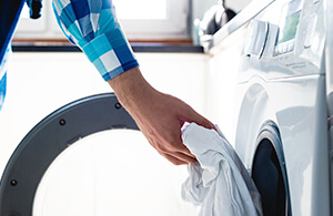 Person putting laundry in washing machine